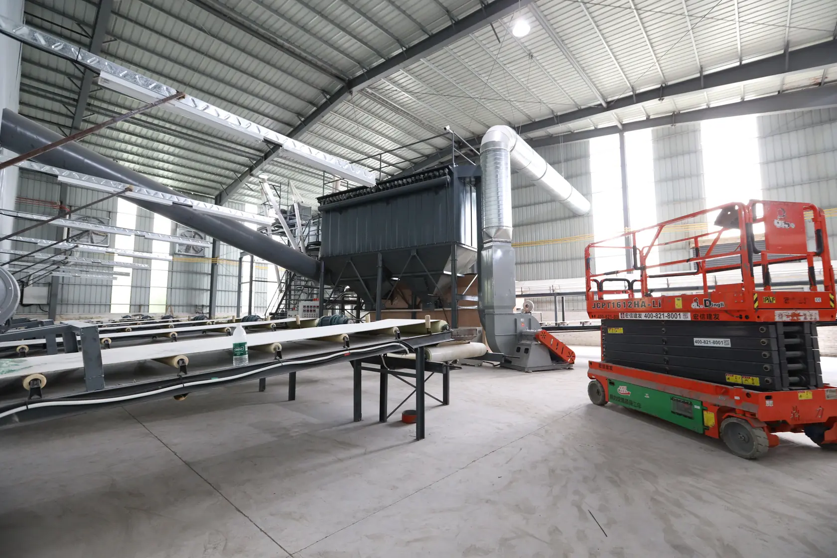 Conveyors and material-processing equipment in a naturally lit workshop